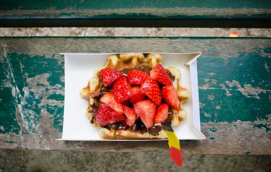 Belgium waffle with chocolate sauce and strawberries. Top view