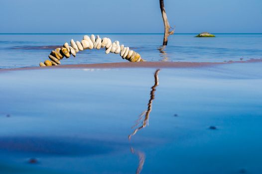 Arch of pebbles on the surface of the sea