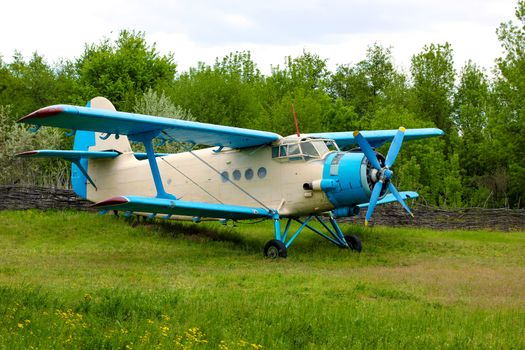 Old retro airplane on green grass field