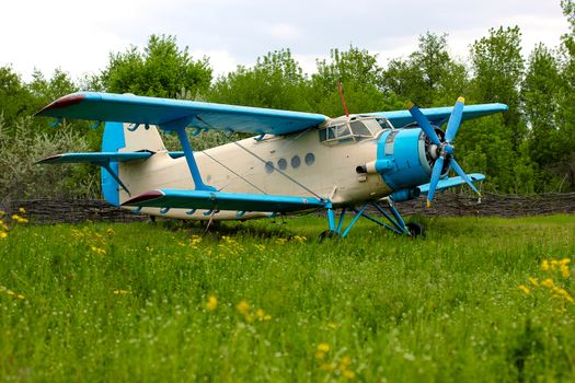 Old retro airplane on green grass field