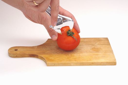 Screw a tomato on a wooden plate