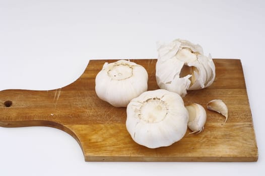 garlic on a wooden plate , isolated 