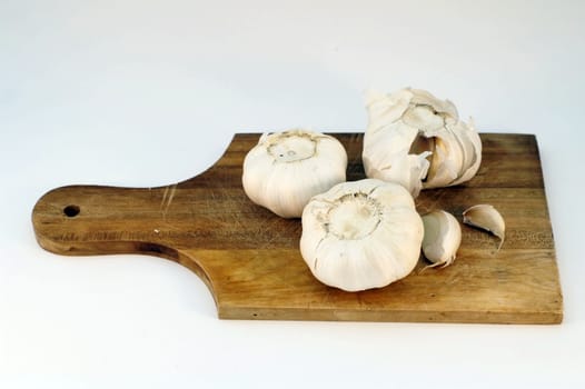 garlic on a wooden plate , isolated 