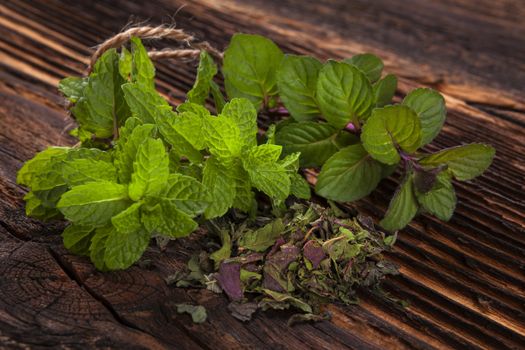 Aromatic culinary herbs, fresh mint herb on wooden rustic background with old vintage scissors.