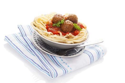 Spaghetti with tomato sauce and meatballs in bowl on cloth isolated on white background. Traditional mediterranean eating. 