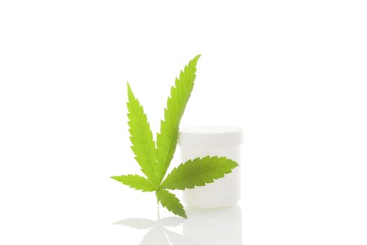 Medical marijuana. Cannabis leaf and white container isolated on white background with reflection