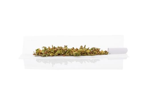 Marijuana bud and cigarette rolling paper isolated on white background. Smoking cannabis, addiction or medical use.