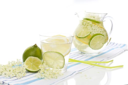 Healthy homemade organic elderberry lemonade with lime slices isolated on white background. Refreshing seasonal nonalcoholic summer drink.