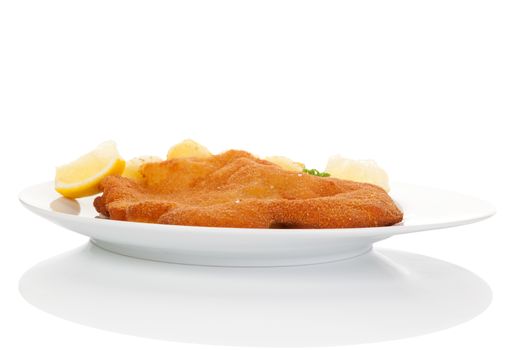 Delicious wiener schnitzel on plate isolated on white background with reflection. Traditional european cuisine.