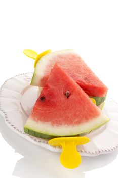 Fresh ripe water melon as ice pop on plate isolated on white background. 