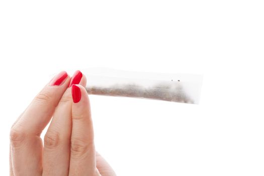 Hands isolated on white background rolling a cannabis joint. Smoking marijuana addiction. Feminine drug abuse. 