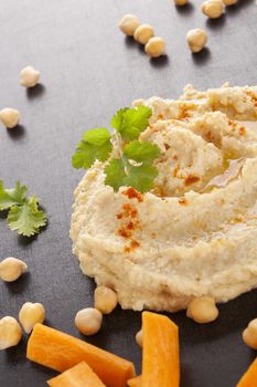Fresh delicious hummus and fresh vegetables, chickpea and herbs. Traditional hummus eating.  