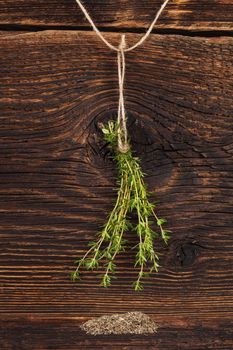 Fresh and dry thyme herb on rustic wooden background. Culinary aromatic herbs.