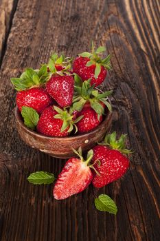 Ripe strawberries on rustic wooden brown table. Healthy fruit eating.