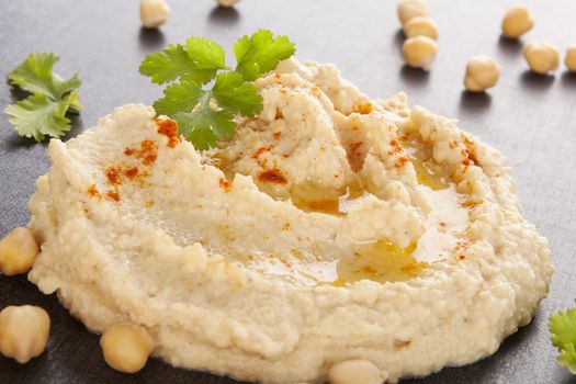 Fresh delicious hummus and fresh vegetables, chickpea and herbs. Traditional hummus eating.  