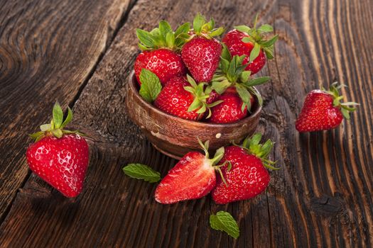 Ripe strawberries on rustic wooden brown table. Healthy fruit eating.