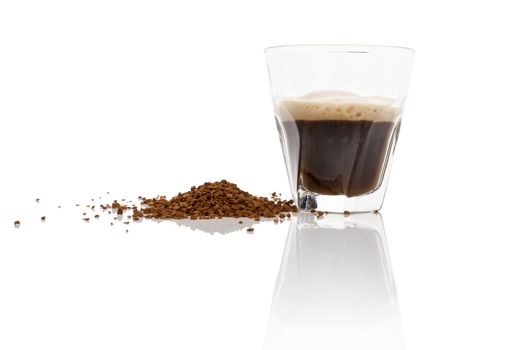 Instant coffee powder and delicious aromatic coffee in glass isolated on white background with reflection. Culinary coffee drinking. 