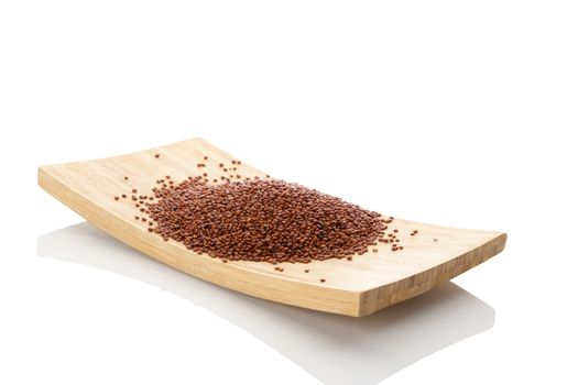 Quinoa seeds on wooden plate isolated on white background. Healthy eating, dietary supplement.