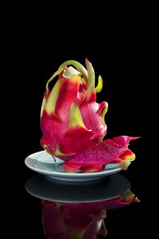 Delicious ripe red dragon fruit isolated on black background. Tropical fruit, pitaya concept. Healthy eating. 