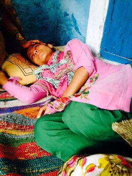 INDIA, Dadri: Shaista, age 16, daughter of Mohammad Ikhlaq who was killed by a mob over rumors that his family had been storing and consuming beef at their home is seen laying on the bed at her home surrounded by her relatives in Dadri, Uttar Pradesh, India on October 1, 2015.