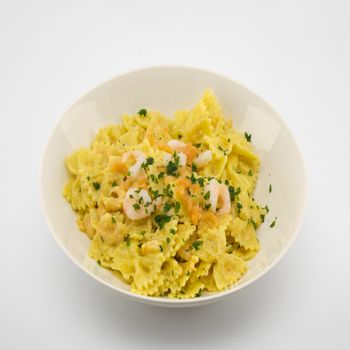 italian traditional pasta called butterflies with shrimp salmon and basil