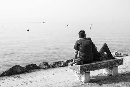 lovers on the bench in front of the lake