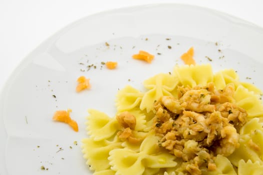 italian traditional pasta called butterflies with shrimp salmon and basil