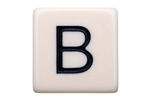 A macro shot of a game tile with the letter B on it on a white background.