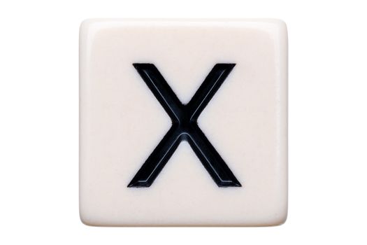 A macro shot of a game tile with the letter X on it on a white background.