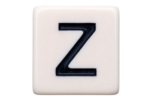 A macro shot of a game tile with the letter Z on it on a white background.