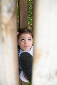 child plays in a wooden outdoor playground