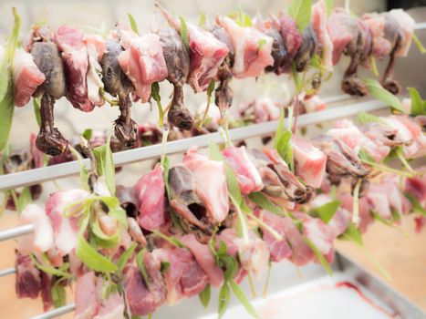 birds on the spit with meat, bacon and sage ready for roasting