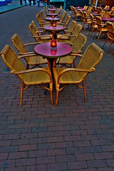 Wicker Chairs and Tables in a Street Cafe at Night