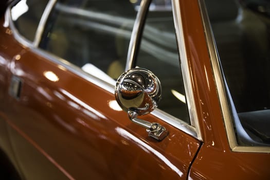 Chrome rearview mirror of a red car