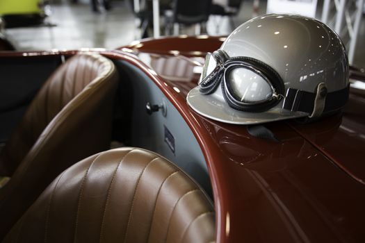 helmet and glasses resting on a luxury convertible sports car