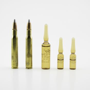 composition with vials and bullets on white background