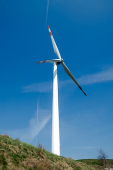 single wind turbine on the hill produces green clean energy