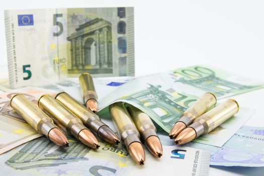 composition with golden bullets and banknotes on white background