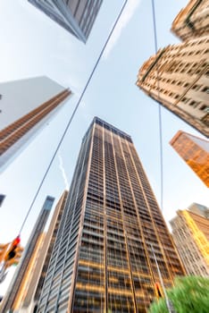 Moving underneath tall skyscrapers, blurred view.