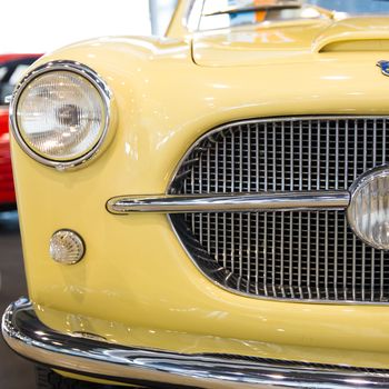 rounded lines and round headlights of a vintage yellow car