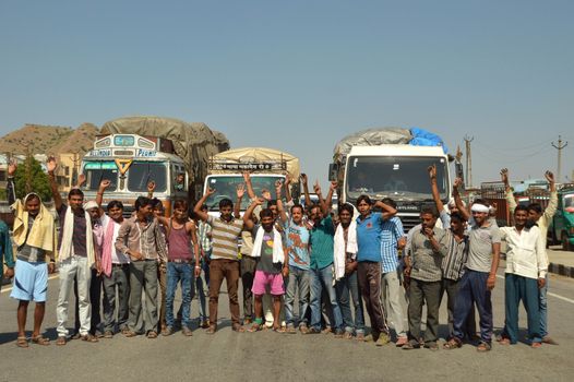 INDIA, Ajmer: A group of transportation workers block the road in Ajmer, India on October 1, 2015 after going on strike. The All India Motor Transport Congress (AIMTC) went on an indefinite strike on October 1, 2015 throughout the country to protest against the present toll system and one time payment of taxes.Nitin Gadkari, Union Road Transport and Highways Minister, offered an electronic toll system available by December but made it clear that scrapping the entire toll system is not an option. The demonstration caused disruptions in the movement of goods in parts of the country.