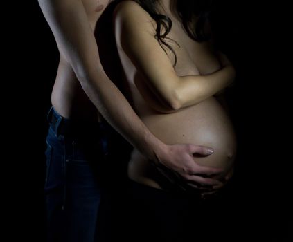 The sweet expectation of a pregnant on dark background.
