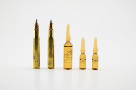 composition with vials and bullets on white background