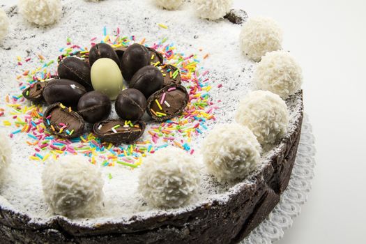 Easter cake with ricotta and chocolate decorated with chocolate eggs and powdered sugar