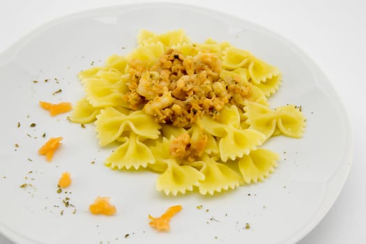 italian traditional pasta called butterflies with shrimp salmon and basil