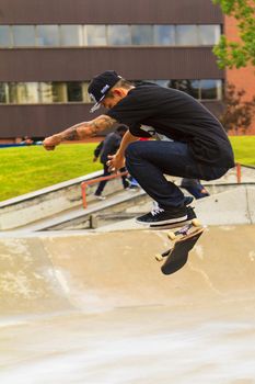 CALGARY, CANADA - JUN 21, 2015: Athletes have a friendly skateboard competition in Calgary. California law requires anyone under the age of 18 to wear a helmet while riding a skateboard.