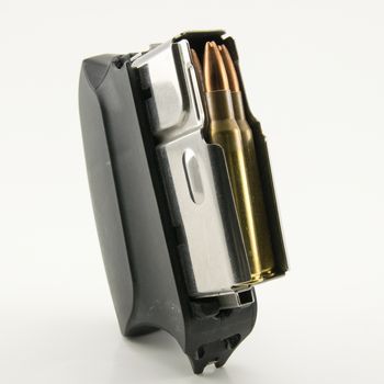 bullets of hunting rifle and charger on white background