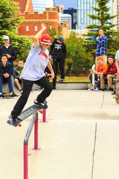 CALGARY, CANADA - JUN 21, 2015: Athletes have a friendly skateboard competition in Calgary. California law requires anyone under the age of 18 to wear a helmet while riding a skateboard.