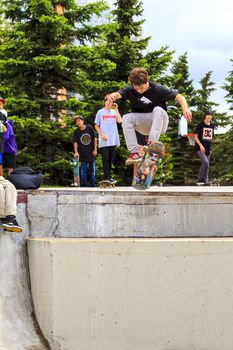 CALGARY, CANADA - JUN 21, 2015: Athletes have a friendly skateboard competition in Calgary. California law requires anyone under the age of 18 to wear a helmet while riding a skateboard.