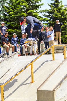 CALGARY, CANADA - JUN 21, 2015: Athletes have a friendly skateboard competition in Calgary. California law requires anyone under the age of 18 to wear a helmet while riding a skateboard.